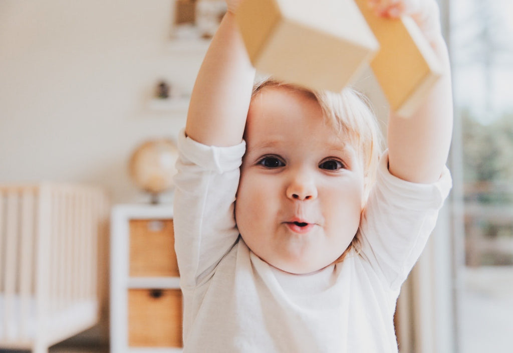 Happy baby with a wooden brick 